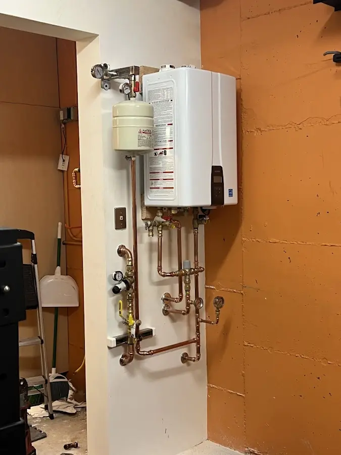 Plumbing technician inspecting water heater connections in Linthicum